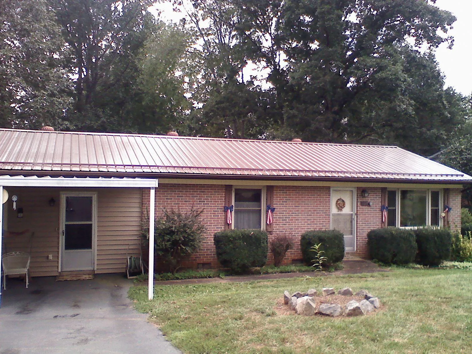 Bronze metal roof and carport on a brick ranch home — Roof Repair work by our crew in Chapel Hill