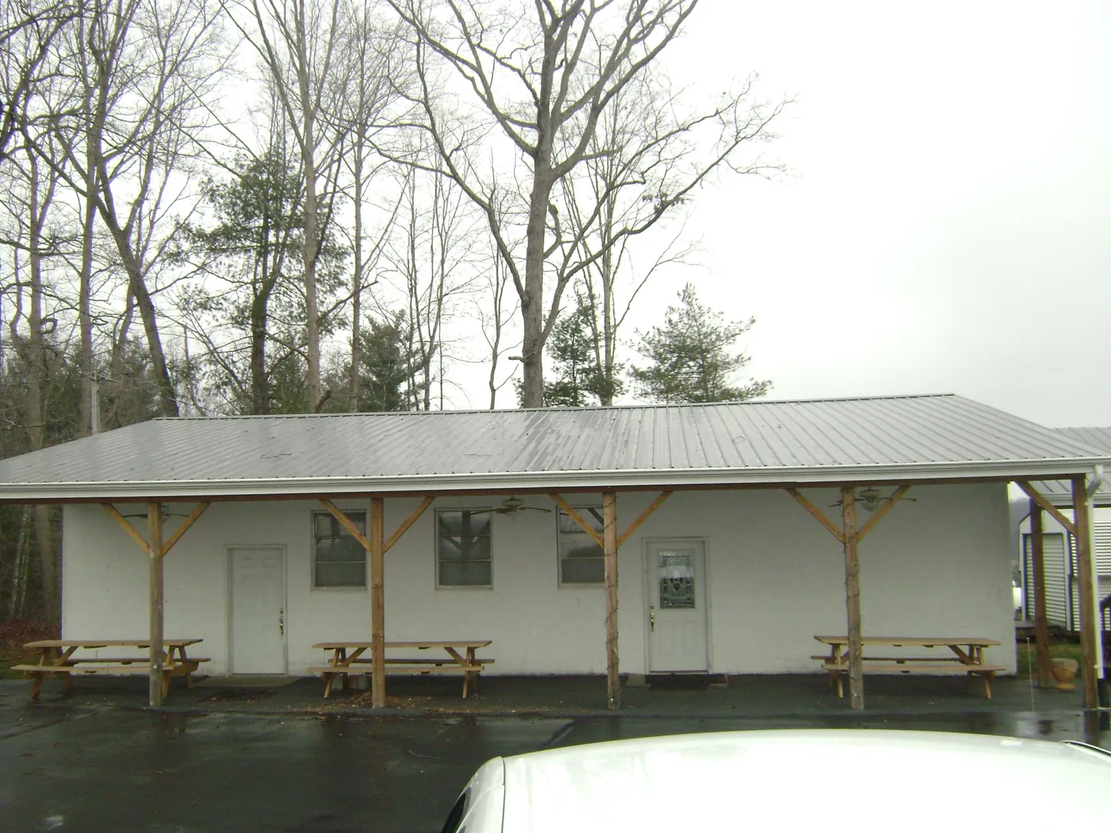 Gray metal roof over a block building with a timber post porch in Chapel Hill